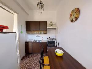 a kitchen with a table and a clock on the wall at Ioanna's House@Foinikas Syros in Finikas