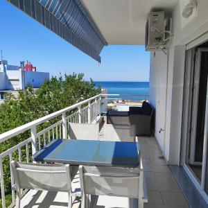 balkon ze stołem i krzesłami oraz oceanem w obiekcie Christina-2 w mieście Perea