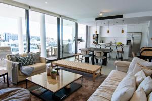 un soggiorno con divani e tavoli e una cucina di Mara's Apartments Higueron West - Scandinavian Luxury - Views of the Sea and Natural Landscapes a Fuengirola