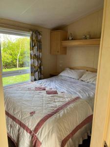 a bedroom with a large bed with a window at Chans Van in Chapel Saint Leonards