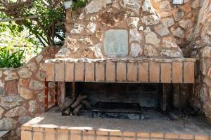 an outdoor brick oven with a stone wall at Kos Dream Beachwalk Apartment in Tigaki