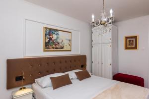 1 dormitorio con 1 cama y una pintura en la pared en Apartments Cime, en Dubrovnik