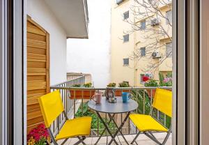 a balcony with a table and yellow chairs at Bingo!!!Studio-5'to Acropolis in Athens