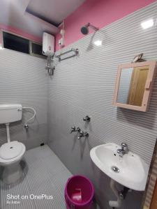 a bathroom with a sink and a toilet and a mirror at Hotel Rose in kolkata