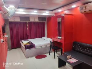 una camera con letto e parete rossa di Hotel Rose a kolkata