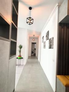 un pasillo con paredes blancas y un pasillo largo en Central, spacius apartment. en Bucarest