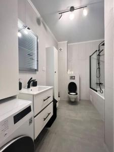 a white bathroom with a toilet and a sink at Central, spacius apartment. in Bucharest