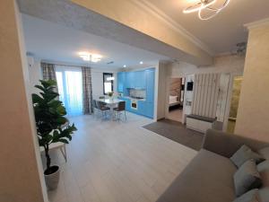 a living room and kitchen with a couch and a table at Cazare Apartmente in SolidHouse Mamaia in Mamaia