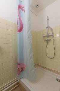 La salle de bains est pourvue d'une douche avec un rideau de douche flamant rose. dans l'établissement Cabana & Miami 70's - Proche Parking et Épicerie, à Mâcon 28 autres photos