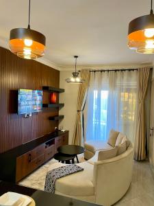 uma sala de estar com um sofá e uma televisão em Athena Apartments em Kampala