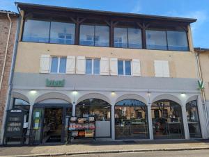 un magasin à l'avant d'un bâtiment avec de grandes fenêtres dans l'établissement Cabana & Miami 70's - Proche Parking et Épicerie, à Mâcon