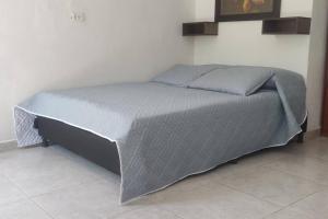 uma cama com um edredão cinzento num quarto em Campo Alegre: Loft con Vista em Medellín
