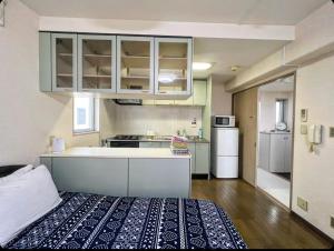 een kleine keuken met een bed in een kamer bij MATUBARA HOUSE in Tokyo