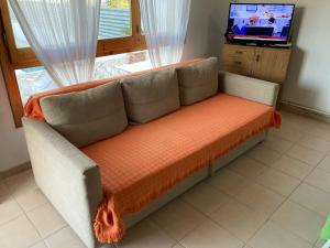 a couch sitting in a living room with a television at Casa Gonia in Riumar