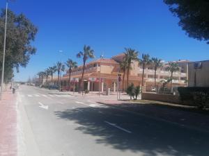 una calle vacía con palmeras y un edificio en Casa Gonia, en Riumar