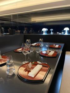 a table in a restaurant with plates and wine glasses at the black line house in Olot