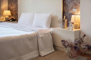 a bedroom with a bed and a nightstand with a white bedspread at Monte Carlo in Batumi
