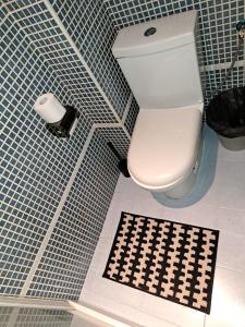 baño con aseo y pared de azulejos en blanco y negro. en LIAM STUDIO IN SEVILLA CENTRIC, en Sevilla