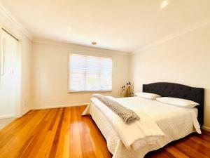 una camera con un grande letto e una finestra di Townhouse Near The World’s Coolest High st in 2024 a Melbourne