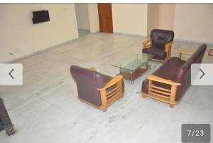 duas cadeiras e uma mesa de vidro num quarto em Shree Eco Stay em Chennai