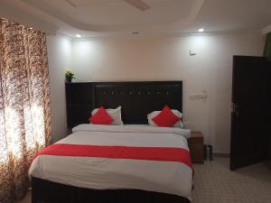 Un dormitorio con una cama grande con almohadas rojas. en vella marina group of hotel Ravine, en Dharamshala
