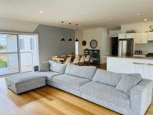 a living room with a gray couch and a kitchen at Salt Life - Pet Friendly Outside WIFI in Robe