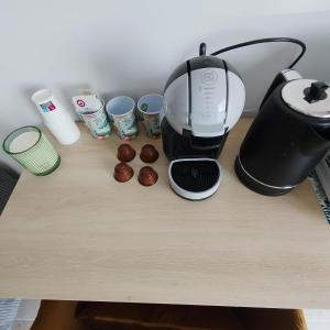 a coffee maker and some cups on a table at Les Jardins Ducarouge 3 climatisé in Digoin +3 photos