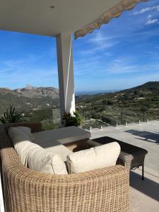 balcón con muebles de mimbre y vistas a las montañas en Villa Guadalest hills, en Guadalest