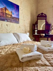 um quarto com uma cama com toalhas e um espelho em Nina em Siġġiewi