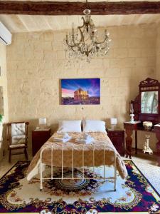 a bedroom with a bed and a chandelier at Nina in Siġġiewi