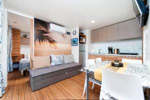 a living room with a couch and a kitchen at Mobile home MAŠA 163, camp Porton Biondi in Rovinj