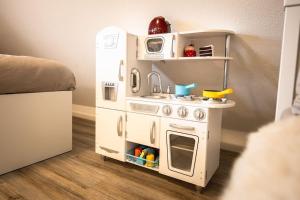 a toy kitchen with a stove and a refrigerator at Villa Vanilla im Burgdorf 11 P. in Neidenstein +32 photos