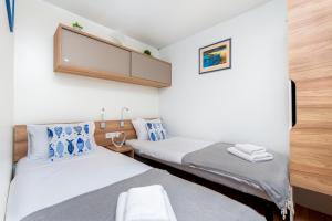 a bedroom with two beds and a flat screen tv at Mobile home MAŠA 163, camp Porton Biondi in Rovinj