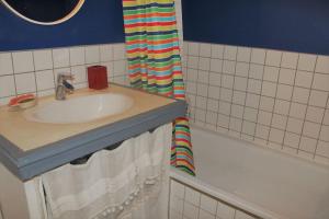 a bathroom with a sink and a shower curtain at Casa Julia, maison familiale in Forcalquier