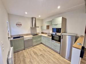 Saint-DésirにあるMaison normande à la campagneのキッチン(青いキャビネット、ステンレス製の電化製品付)