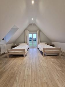 Saint-DésirにあるMaison normande à la campagneの屋根裏のベッドルーム(ベッド2台、窓付)