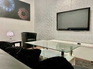 a living room with a glass table and a flat screen tv at Luxury Premium Furnished Apartment in Bonn