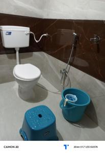 a bathroom with a toilet and a bucket at Shree shiv tara guest house in Ujjain