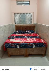 a bedroom with a bed with a red comforter at Shree shiv tara guest house in Ujjain