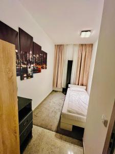 a small room with a bed and a dresser in it at Luxury Premium Furnished Apartment in Bonn