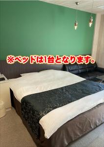 宮崎的住宿－Hotel 4Season，卧室配有一张挂有墙上标志的床