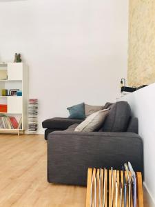 a black couch in a living room with a wooden floor at Duplex en el centro de Alicante in Alicante