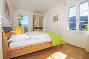 ein Schlafzimmer mit einem Bett mit weißen Kissen und einem Fenster in der Unterkunft Residence Diana in Meran