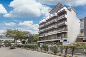 un edificio con un autobus parcheggiato di fronte di Stepstones Hotels and Inn-DLF PHASE 3 GURGAON a Gurgaon