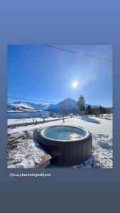 蘇特蘭的住宿－Cozy home in Godfjord，雪中的一个热水浴缸,太阳在背后