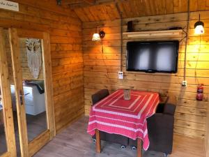 jadalnia ze stołem i telewizorem w kabinie w obiekcie Vakantiehuis 't Klavertje w mieście Noordwijk