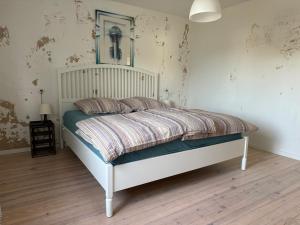 a bedroom with a bed with a white headboard at Ferienwohnung Rhön in Bastheim