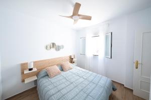 a bedroom with a bed and a ceiling fan at Alojamiento Erytheia, tranquilo, a 150 metros de la playa y pleno casco histórico in Conil de la Frontera