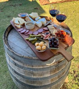 a wooden table with food and wine glasses on a barrel at Barossa Garden Homestay in Williamstown