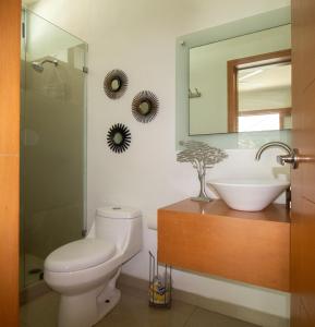 uma casa de banho com um WC, um lavatório e um espelho. em Pacific Shores Retreat & Getaway em Nuevo Vallarta 